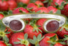 Handmade sterling silver cuff with two oval pink "strawberry" quarts stones. Background is strawberry wallpaper.