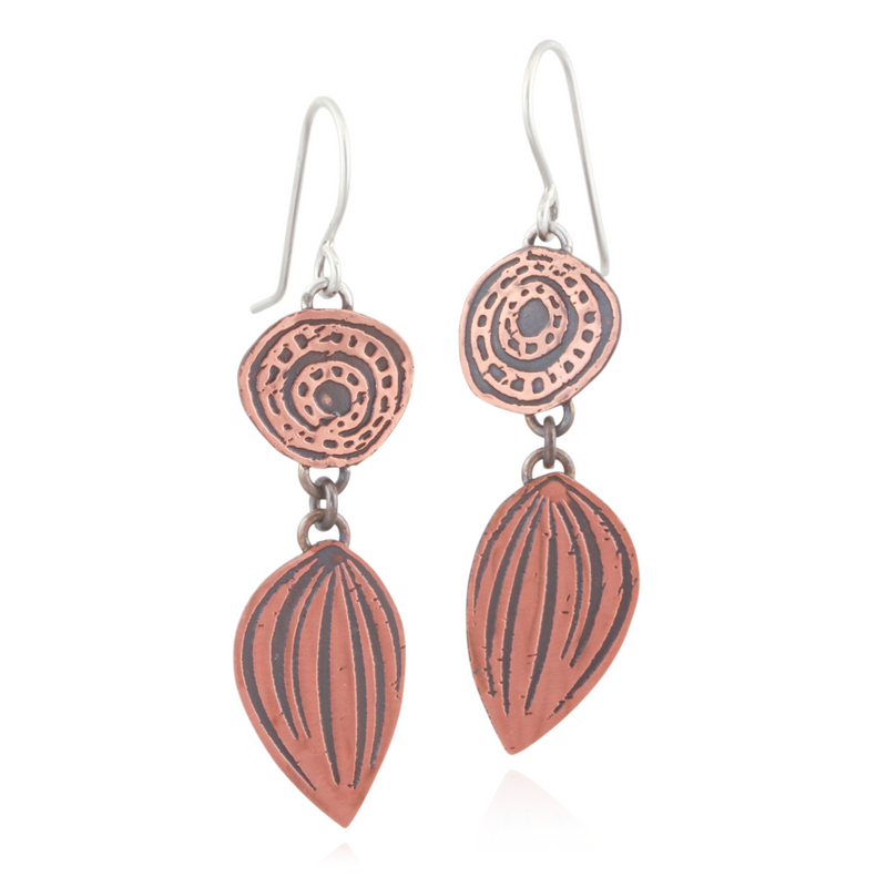 Copper earrings with circular and leaf-shaped designs on a white background