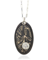 Necklace with an oval pendant featuring leaf patterns and white cubric zirconia gemstone on a white background
