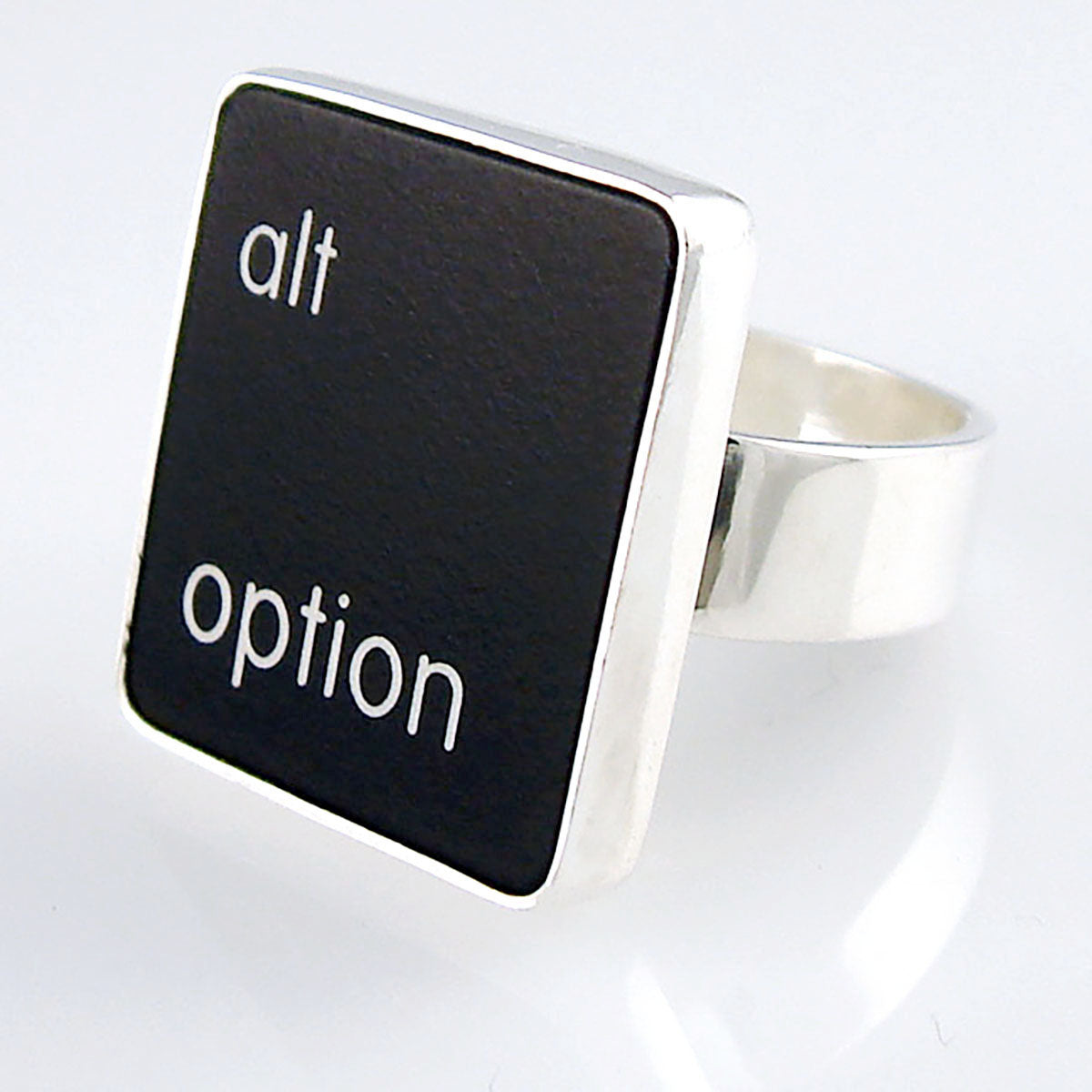 A silver ring featuring a black vertical rectangle with the words 'alt option' printed in white lowercase text, photographed on a clean white background.