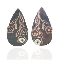 Teardrop-shaped earrings with floral designs and green peridot gemstones on a white background