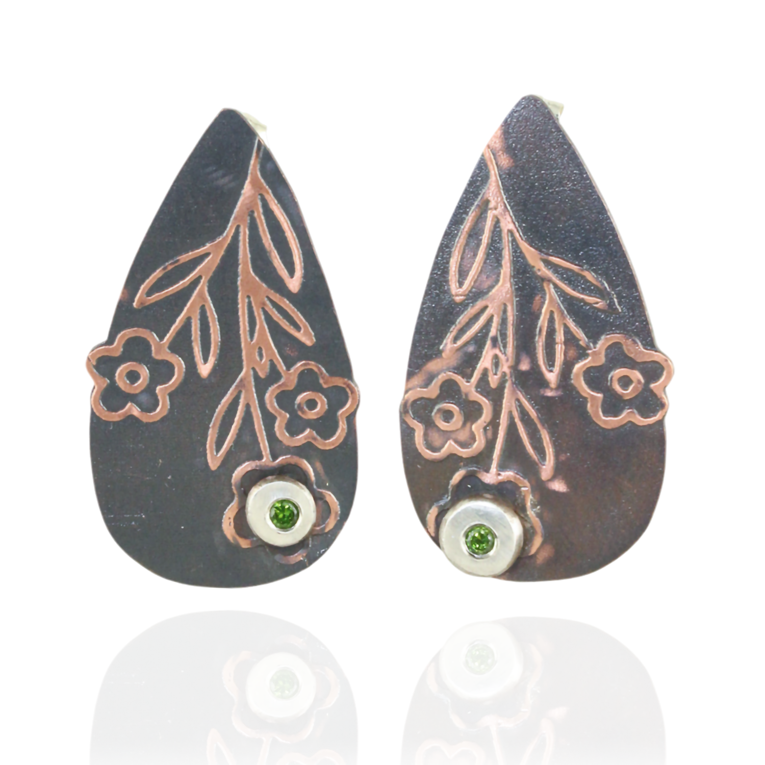 Teardrop-shaped earrings with floral designs and green peridot gemstones on a white background