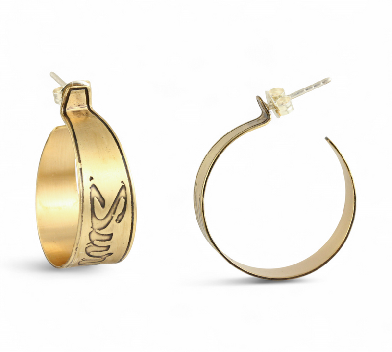 Handmade nu-gold brass hoop earrings with engraved Survive design on a white background.