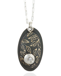 Necklace with an oval pendant featuring leaf patterns and white cubric zirconia gemstone on a white background