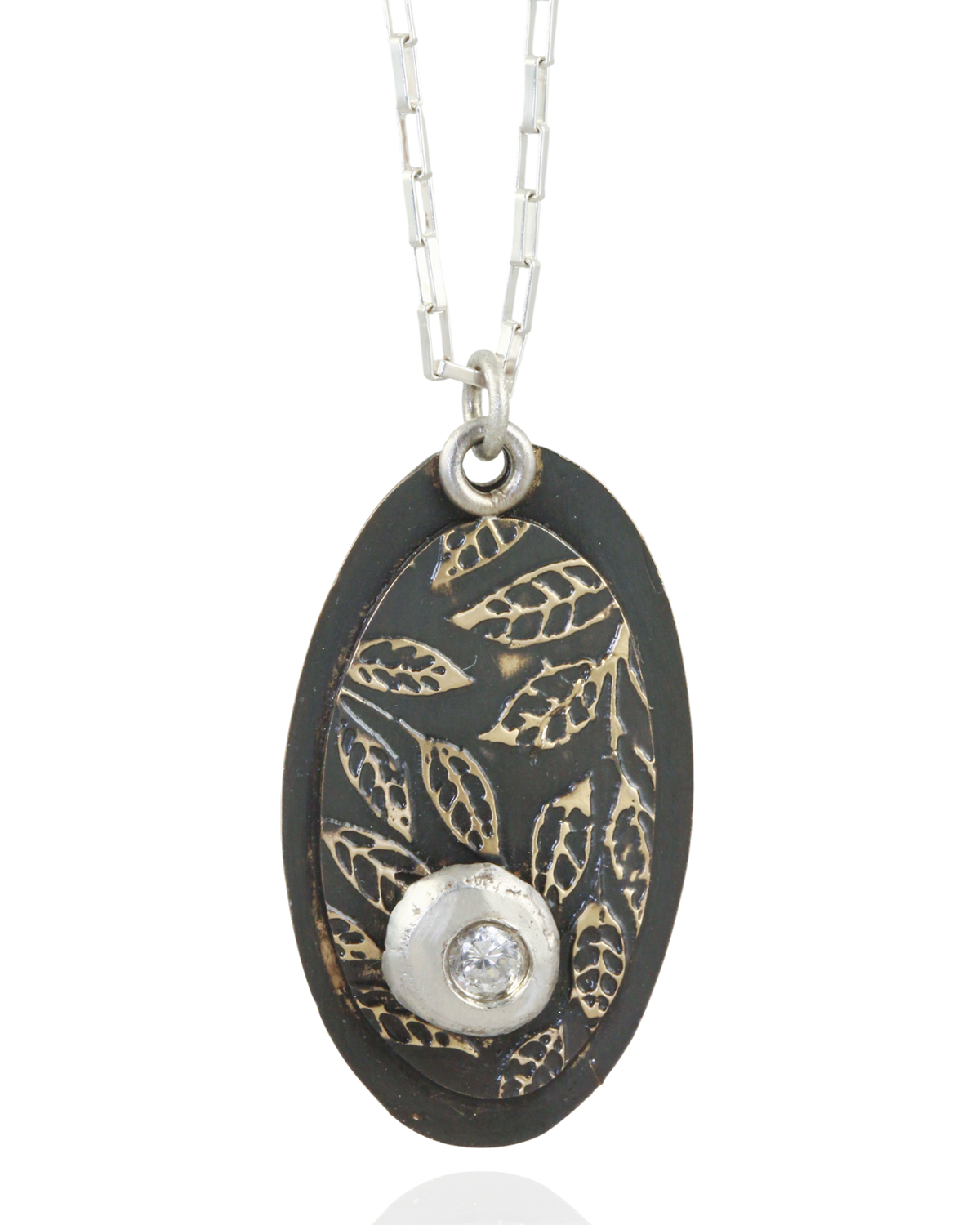Necklace with an oval pendant featuring leaf patterns and white cubric zirconia gemstone on a white background