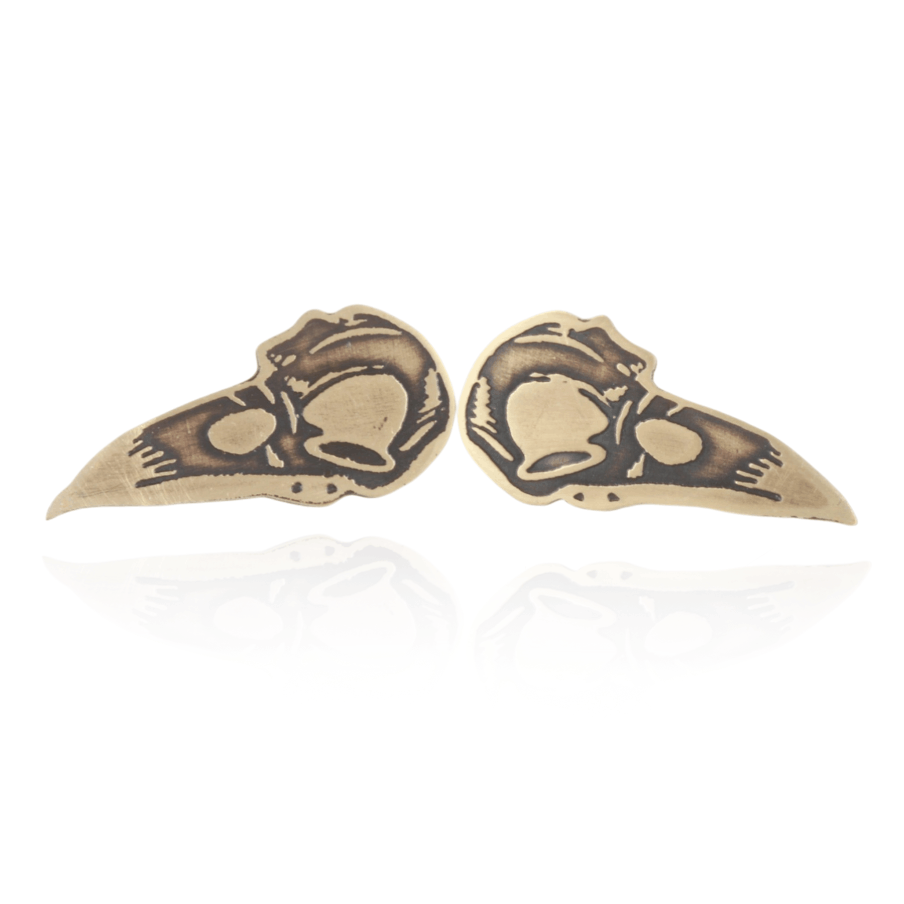 Pair of gold bird skull earrings on a white background