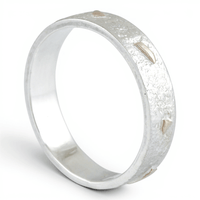 Silver ring with a textured gold surface on a white background