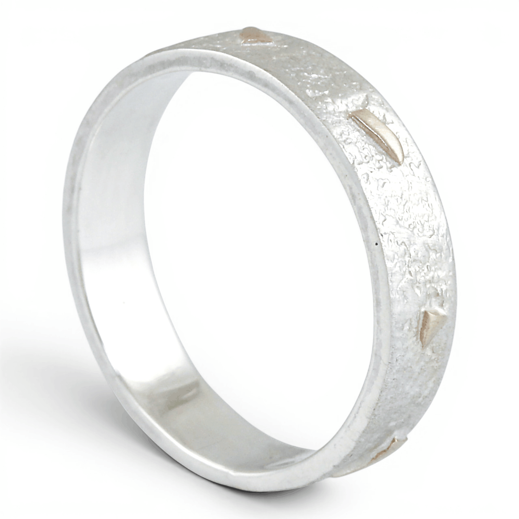 Silver ring with a textured gold surface on a white background