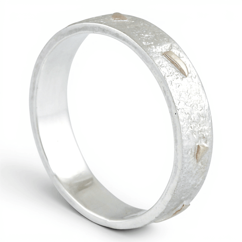 Silver ring with a textured gold surface on a white background