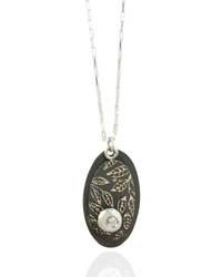 Necklace with an oval pendant featuring leaf patterns and white cubric zirconia gemstone on a white background