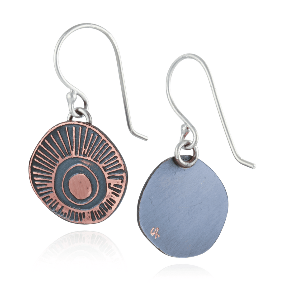 Pair of earrings with one having a circular design and the other a flat, round shape on a white background.
