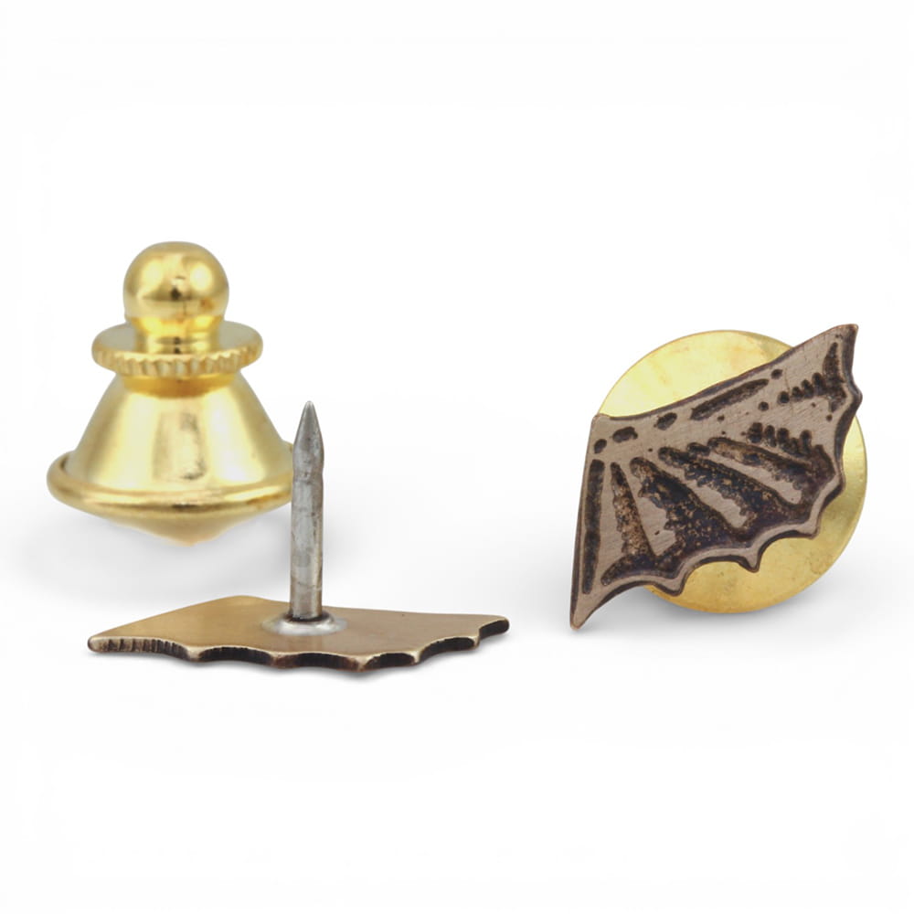 Brass Bat-shaped pin on a white background