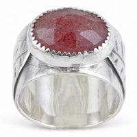 Silver ring with a pink oval stone on a white background