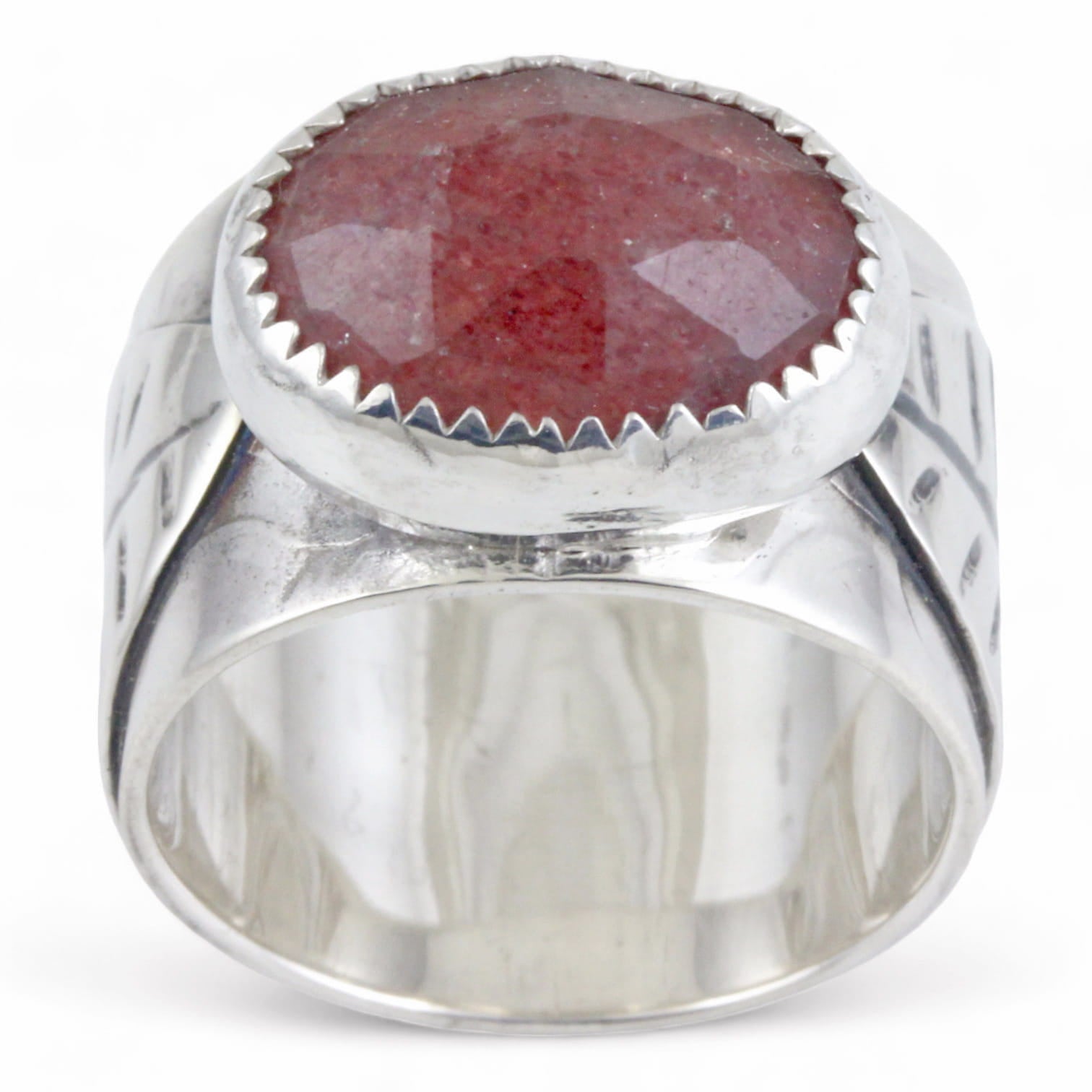 Silver ring with a pink oval stone on a white background