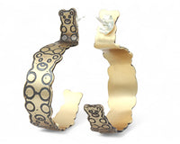 Gold hoop earrings with a interlocked teddy bear pattern on a white background.