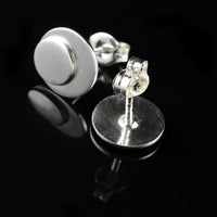 Sterling silver polka dot button earrings on a black background.