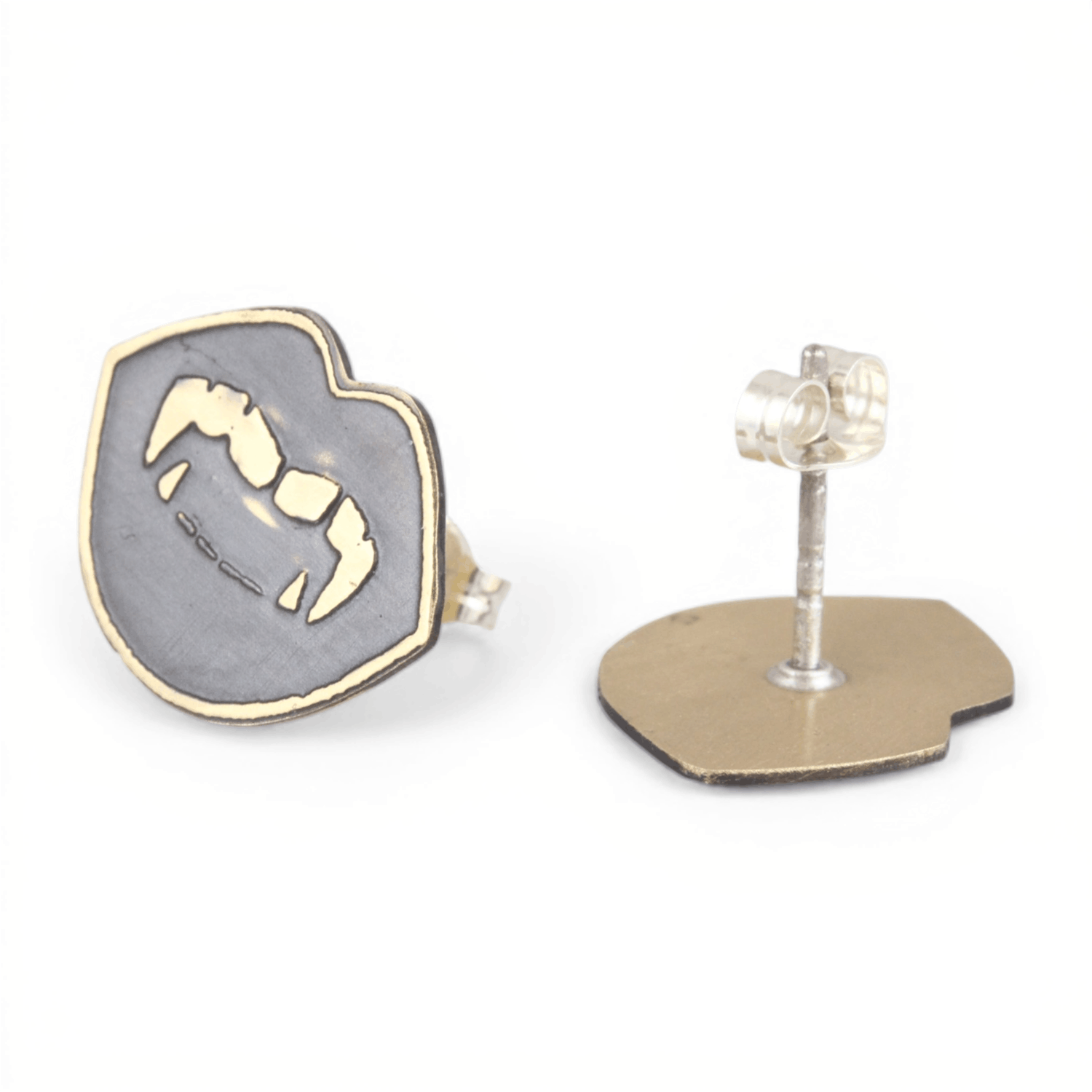 Pair of gold oxidized metal vampire fang lip shaped earrings on a white background