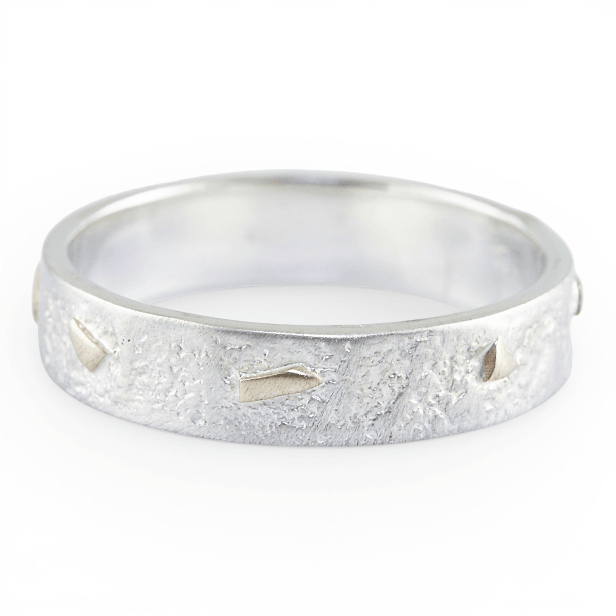 Silver ring with a textured gold surface on a white background