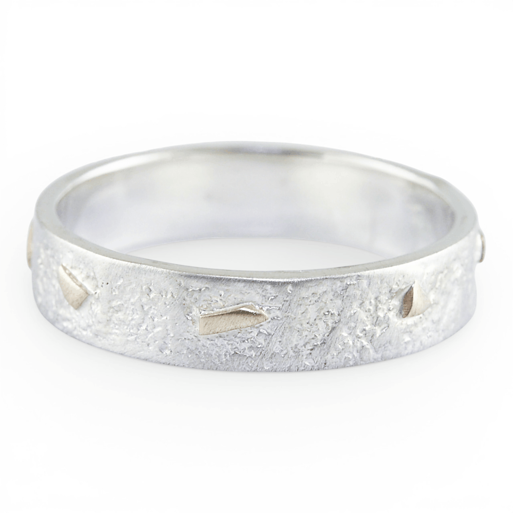 Silver ring with a textured gold surface on a white background