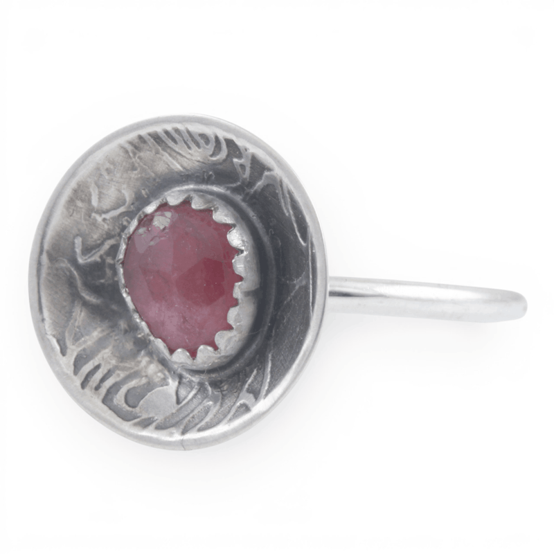 Silver dome ring with a pink gemstone on a white background