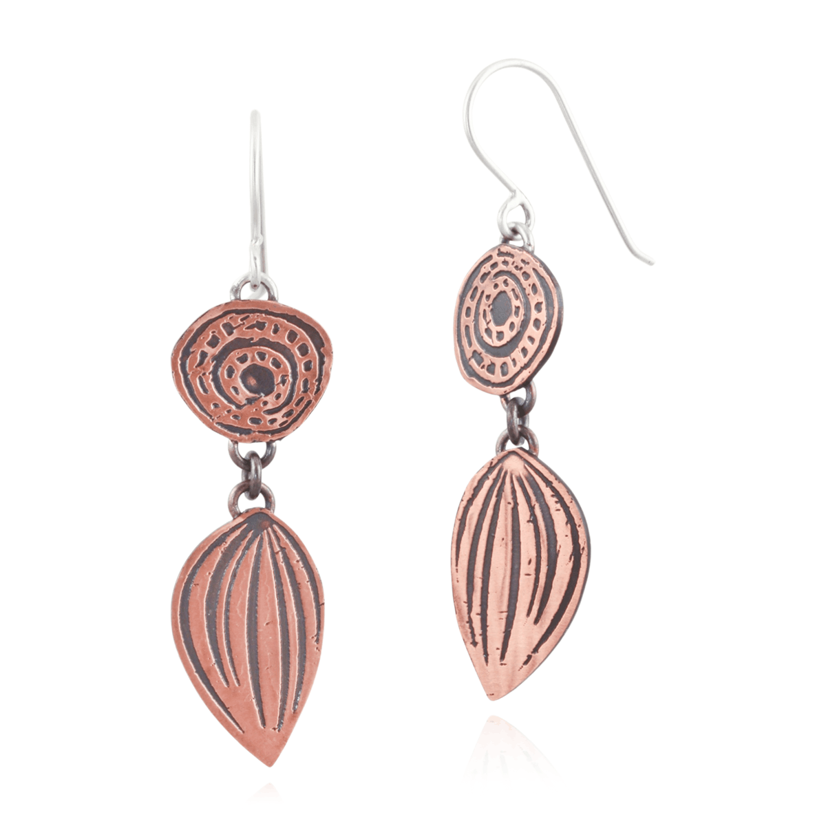 Copper earrings with intricate designs on a white background