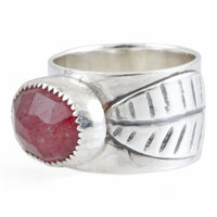 Silver ring with a pink stone and leaf design on a white background
