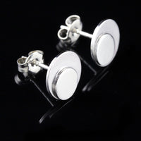Sterling silver polka dot button earrings on a black background.