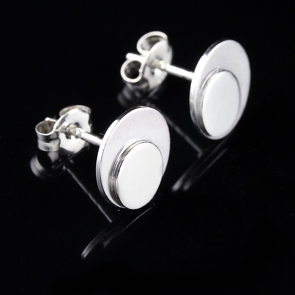 Sterling silver polka dot button earrings on a black background.