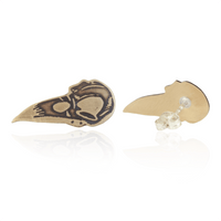 Bird skull-shaped earring with a clear gemstone on a white background