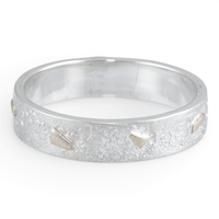 Silver ring with a textured gold surface on a white background