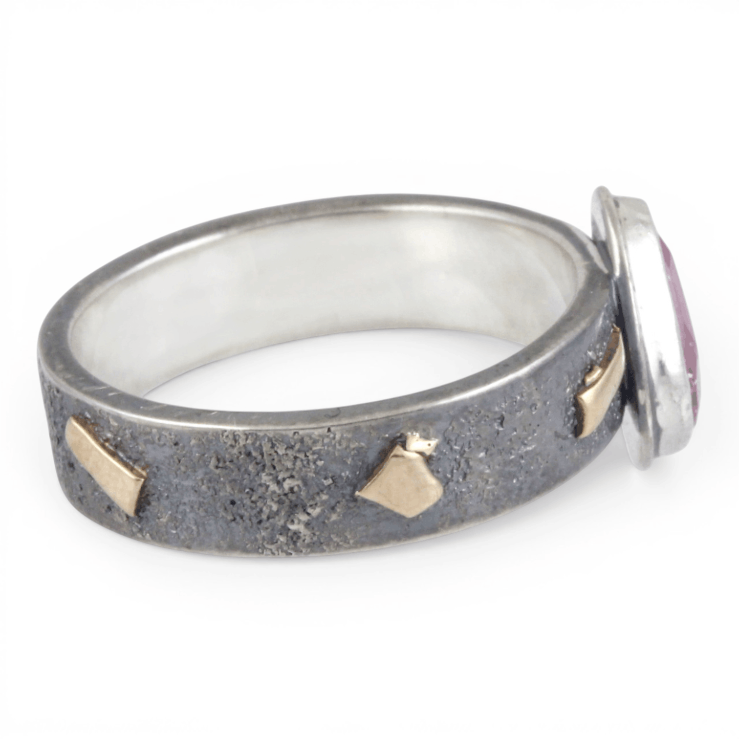 Silver ring with gold and a pink stone on a white background