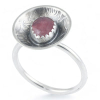 Silver dome ring with a pink gemstone on a white background