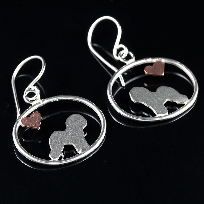 Bichon Frise dangle earrings with sterling silver silhouette and small copper heart in oval frame on black reflective background