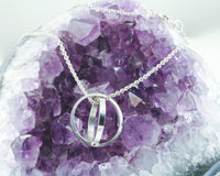 Absolute Cycle - Geometric Orb Pendant by Creative Dexterity - draped over a amethyst crystal.
