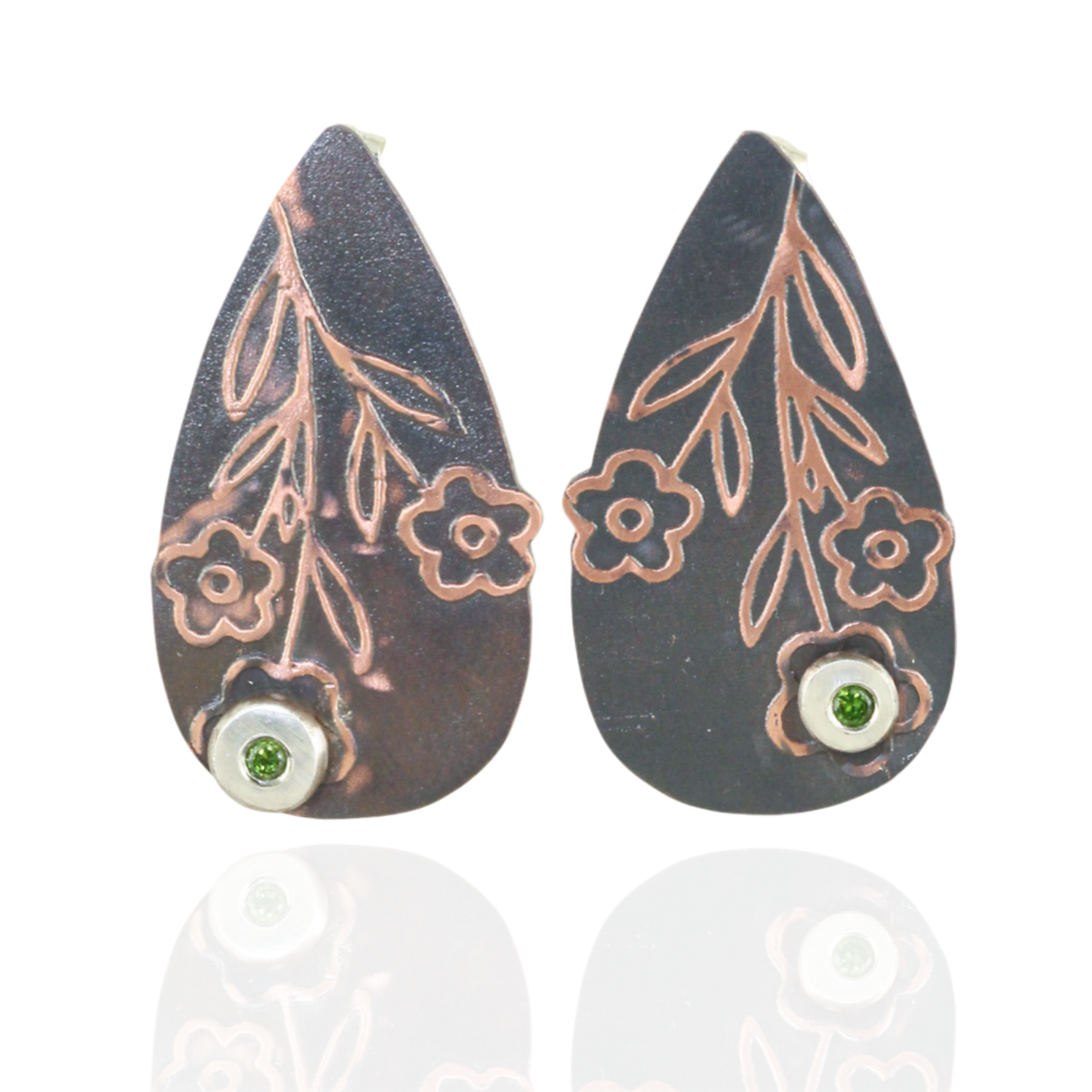 Teardrop-shaped earrings with floral designs and green peridot gemstones on a white background