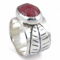 Silver ring with a pink stone and leaf design on a white background