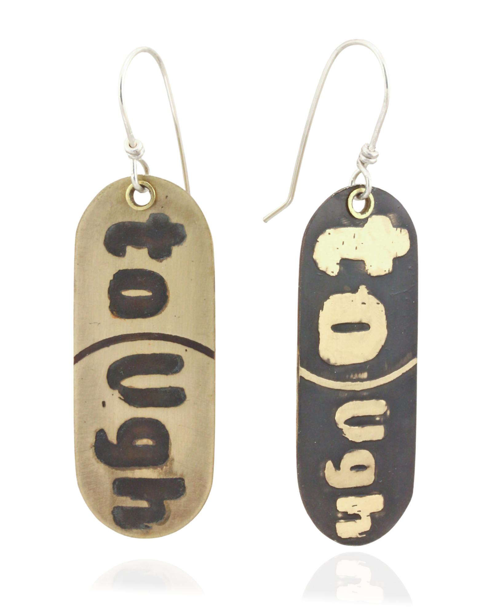 Pair of handmade brass earrings with 'Tough' text on a beige and black background. Front View