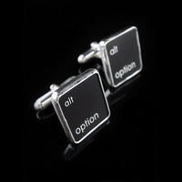 Cufflinks with 'alt option' text on black keys against a black background