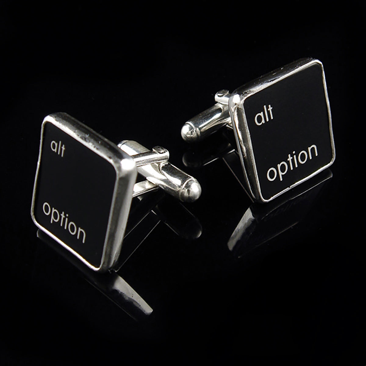 Cufflinks with 'alt option' text on black square buttons against a black background