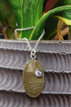 Pendant A: Brass botanical themed pendant with cubic zirconia (upper right), on sterling chain.