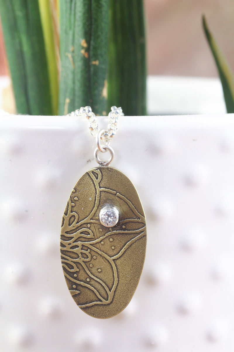 Pendant B: Brass botanical themed pendant with cubic zirconia (upper middle), on sterling chain.