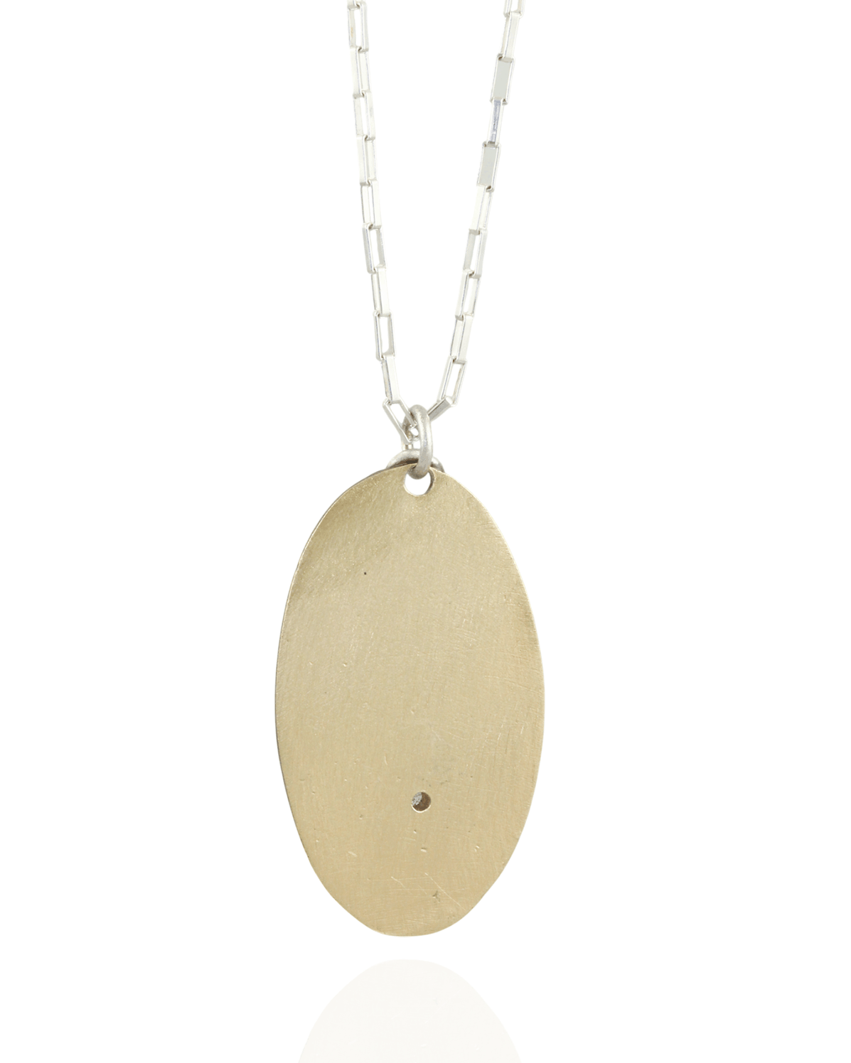 Gold oval pendant on a silver chain against a white background