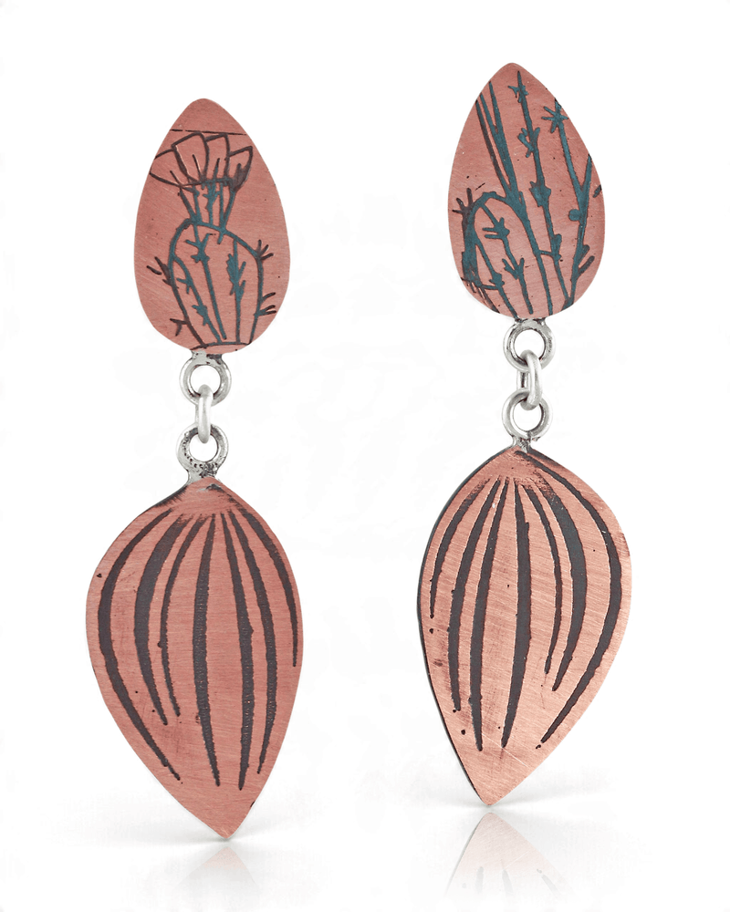 A pair of handmade drop earrings featuring a terracotta-colored top piece engraved with a cactus design, connected by silver rings to a larger, ribbed terracotta-colored teardrop-shaped piece below, set against a plain white background.