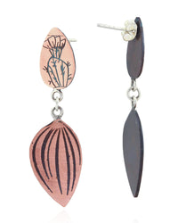 A pair of handmade dangle earrings on a white background. One earring is shown from the front, featuring a copper-colored top oval piece with a black hand-drawn botanical design, connected to a larger leaf-shaped drop piece with black vertical stripes.