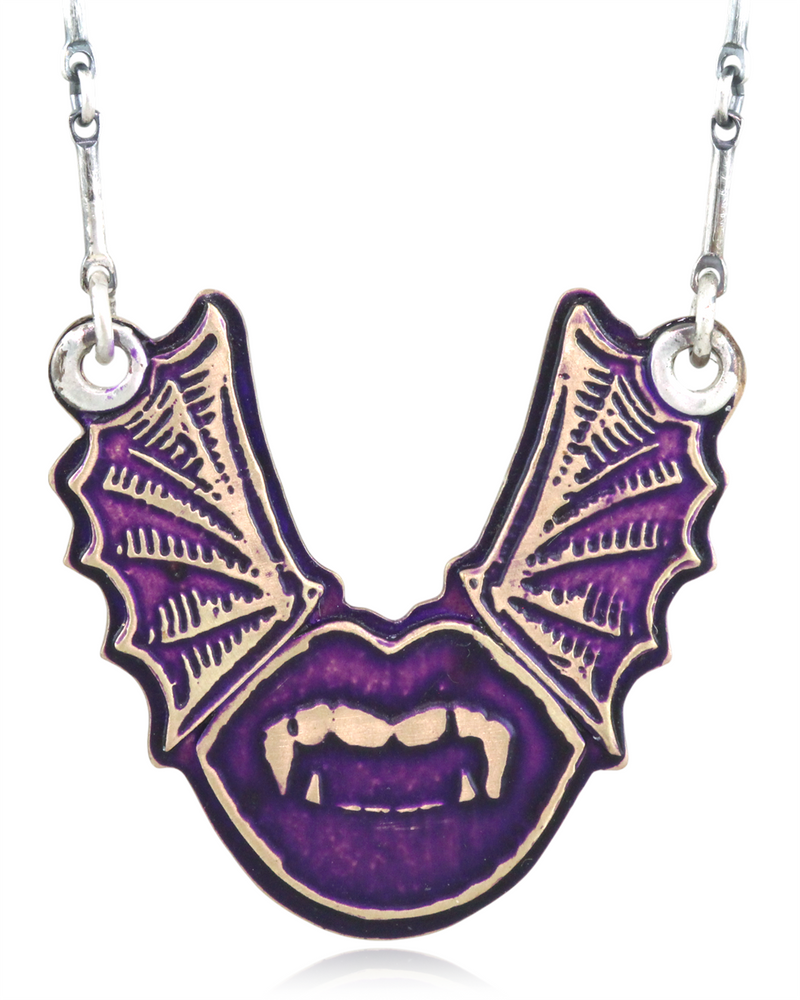 Necklace with a purple and gold bat-shaped pendant with vampire lips on a white background