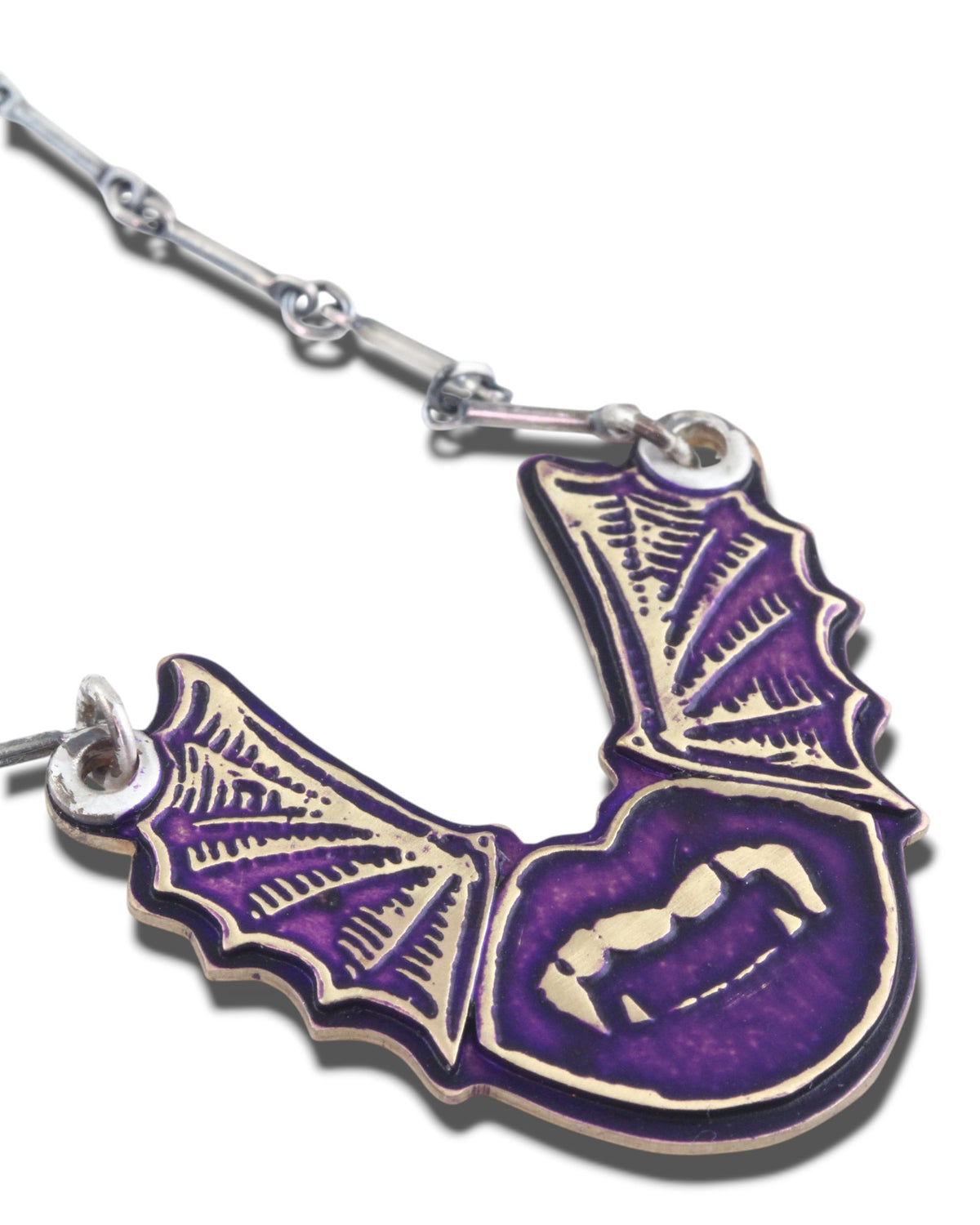 Necklace with a purple and gold bat-shaped pendant with vampire lips on a white background