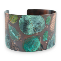 Cuff bracelet with green leaf pattern on a white background