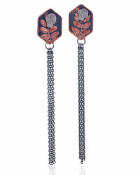 Pair of copper hexagon shaped earrings with silver skull designs and chain fringe details on a white background.