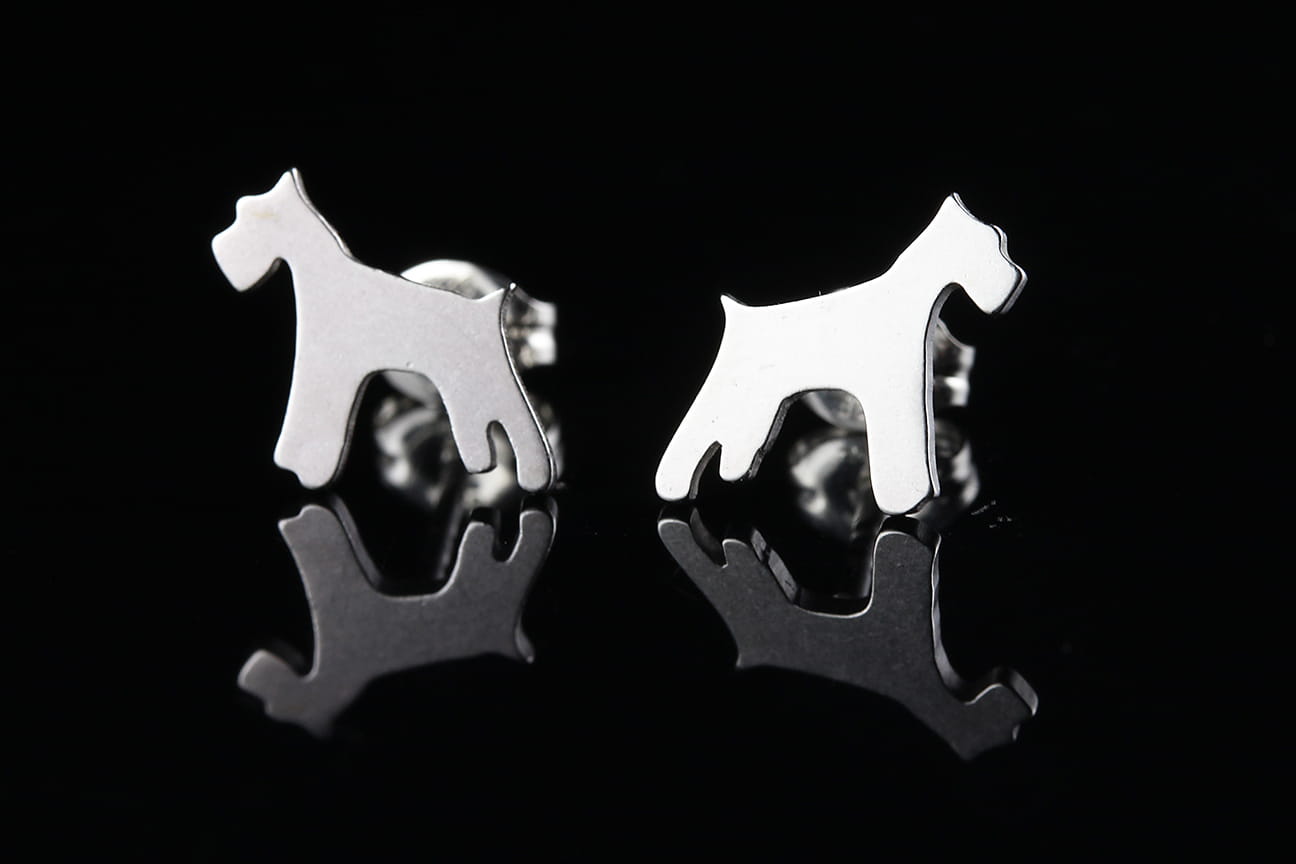 Silver dog-shaped Schnauzer breed earrings on a black background.