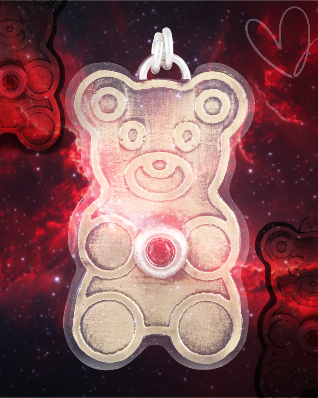 Gold teddy bear-shaped pendant with a red ruby gemstone on a red and black Nebula background